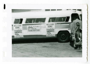 Photograph of bus with signs welcoming the Globetrotters home