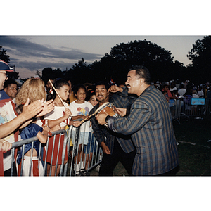 A man lets a child from the audience play the drum in his hands at the Festival Puertorriqueño