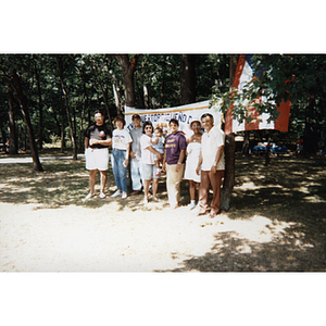 Carmen Pola and others stand in front of a Festival Puertorriqueño banner at a picnic event