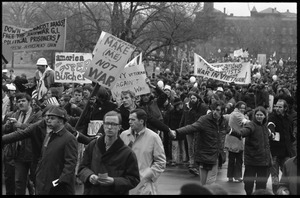 Anti-war protesters marching at the Counter-inaugural demonstrations, 1969, with banners and signs: 'Make me, not war'