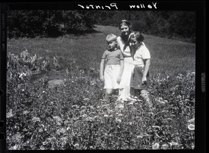 Dorothy Thompson, her son Michael Lewis, and unidentified girl standing in a field of flowers