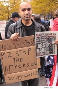Occupy Wall Street: demonstrator holding copy of the New York Post and a sign that reads, 'New York Post, plz. stop the attacks on Occupy Wall St.'