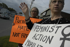 Protest against a pornographic video store in Northampton: protesters holding sign reading 'Pornography is hate speech, not free speech' and 'Feminist Action Mobilization'