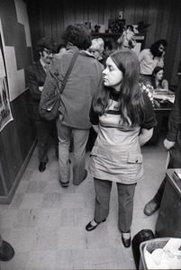 Bernadette Devlin McAliskey standing in the WBCN office, Charles Laquidara on phone in background