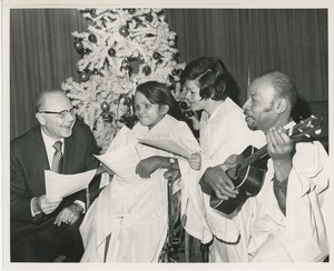 Dr. DiMichael singing with client in front of Christmas tree