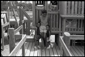 Irma McClaurin with two children atop playground equipment