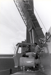 Mayor Raymond L. Flynn operating a crane with an unidentified man looking on