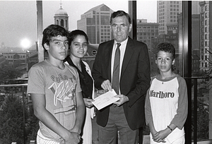 Mayor Raymond L. Flynn presenting a check to an unidentified girl accompanied by two unidentifed boys