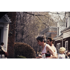 View of runners and crowd in front of houses during Boston Athletic Association (BAA) marathon