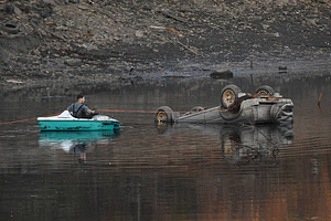A workman preparing a vehicle to be removed from Lake Massasoit (2020)