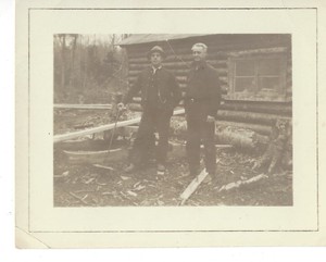 Log Cabin and two men Cellar Rats Building Cabin in Maine