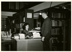 Suffolk University student checking out book at library