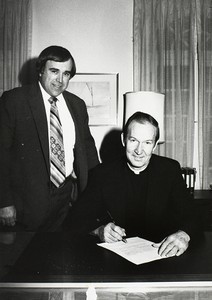 University President Fr. J. Donald Monan signing papers