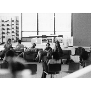 People seated and talking in an unidentified library, at a La Alianza retreat, [Aug.?] 1978