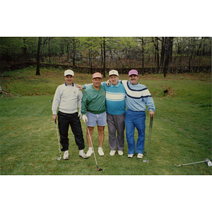 A four-man golf team standing on the golf course with their arms around each other at a Boys and Girls Club Golf Tournament