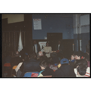 A man speaks into a microphone, two women stand beside him at the MADD 1991 Poster and Essay Contest