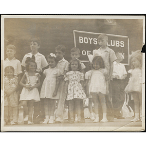 Six girls standing on the stage with their brothers during a Boys' Club Little Sisters' Beauty Contest