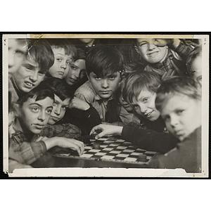 A group of boys pose for a candid group shot around a checker board