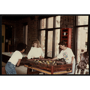 Three girls play foosball