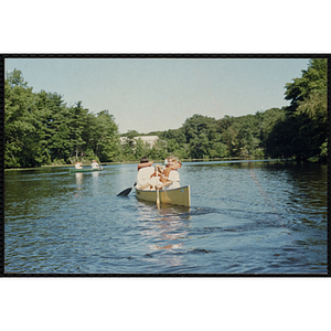 Children navigate canoes on a lake