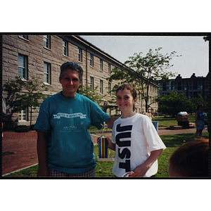 A girl holding a trophy poses with a woman during the Battle of Bunker Hill Road Race