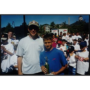 Executive Director Jerry Steimel poses with a boy holding a trophy at the Battle of Bunker Hill Road Race