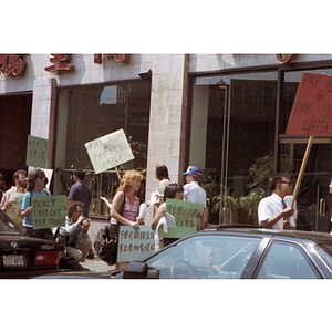 Demonstrators holding protest signs, picketing for back wages for workers at Dynasty Restaurant