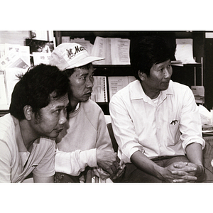 Three Lei Jing Restaurant construction workers seated, talking and organizing at the Chinese Progressive Association headquarters