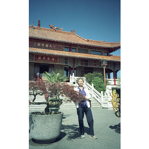 Woman stands outside of a building built in a Chinese style