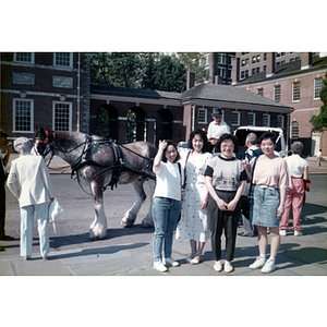 Four women stand in front of a horse-drawn carriage at Philadelphia's Independence Hall