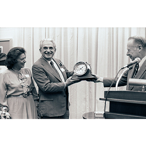 Ellen and George S. Kariotis, left, receive clock from President Kenneth G. Ryder at the Kariotis Hall dedication