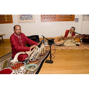 Two musicians sit on the floor of the Museum of Fine Arts at the inauguration of President Aoun