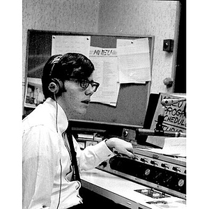 Young man wearing headphones in the broadcast booth of the WNEU studio