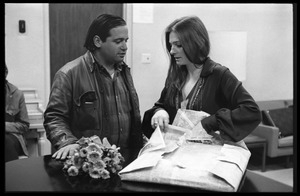 Unidentified man talking to Judy Collins (right) as she unwraps a package in the sound studio while producing the first Crosby, Stills, and Nash album