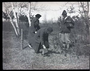 Thomas and Blanche Dreier, unidentified woman, crossing under a barbed wire fence with cameras