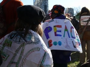 Woman among the protesters on the National Mall, marching against the War in Iraq and wearing a banner reading 'Peace: boo war'