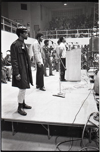 Huey P. Newton speaking at Boston College: Newton at podium, surrounded Party members