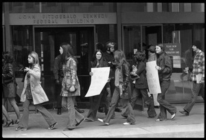 Women Antiwar protesters picketing the entrance to the John F. Kennedy Federal Building as police stand by