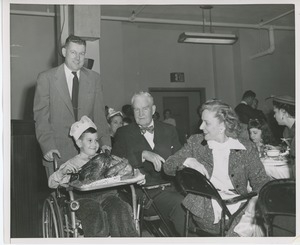 Willis C. Gorthy, Bruce F. Barton, and Connie Boswell with young patient holding Thanksgiving turkey