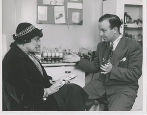 A woman takes notes while a doctor speaks