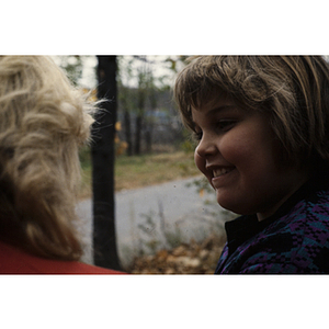 Child smiling at woman on nature walk
