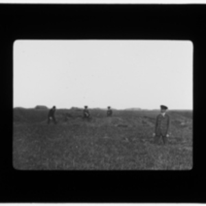 Four men in uniform stand in a field