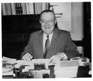Suffolk University Dean Frederick A. McDermott (Law, 1956-1964), seated behind desk