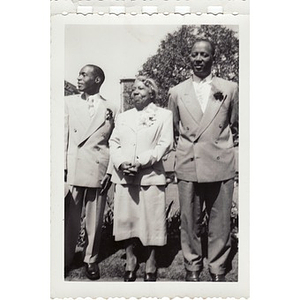 Two men pose with an older woman