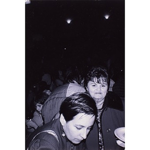 Two women in a crowd at night.