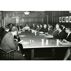 Staff members sit around tables for a training session offered by Boston University School of Social Work at the Charlestown Clubhouse