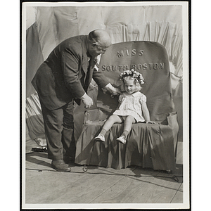 J. Willard Hayden looks at Miss South Boston, the winner of the Boys' Club Little Sister Contest, after placing a flower crown on her