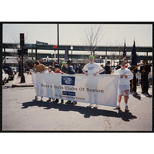 Six boys holding a large banner displaying the text "Boys and Girls Clubs of Boston 100 Years Of Celebrating Youth" during the Boys and Girls Clubs of Boston 100th Anniversary Celebration Parade