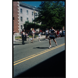 A man runs past spectators during the Battle of Bunker Hill Road Race