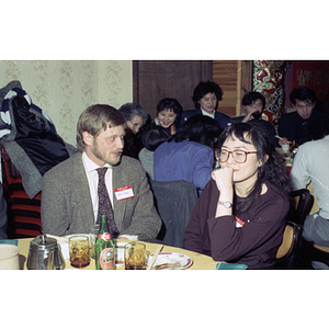 Bob Lewis chats with a woman at a restaurant table for a celebration of the Chinese New Year held by the Chinese Progressive Association